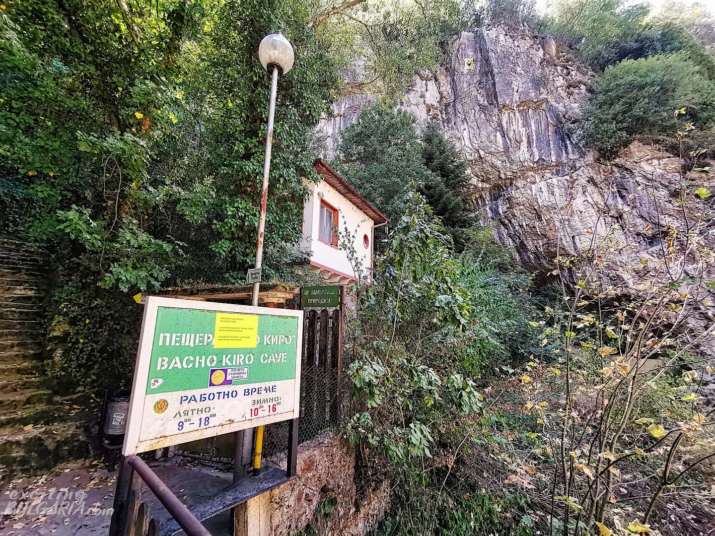 A sign with the opening hours of the Bacho Kiro cave